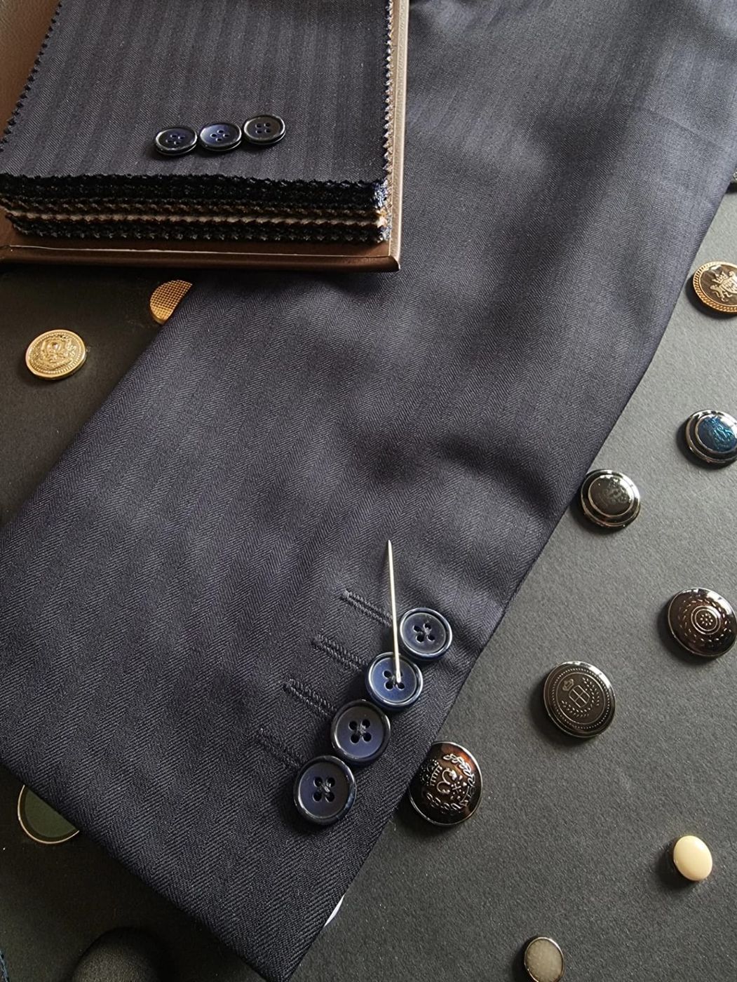Horn and metal buttons laid on navy cloth