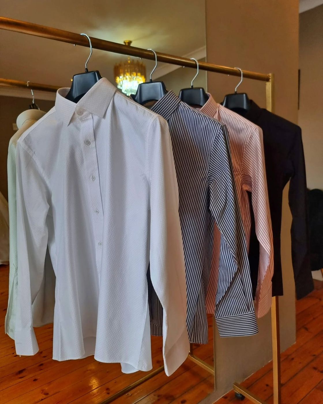 Custom shirts in white, blue, pink and navy on a rail