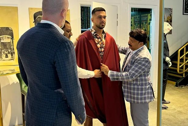 A client being fitted for a long coat in the studio
