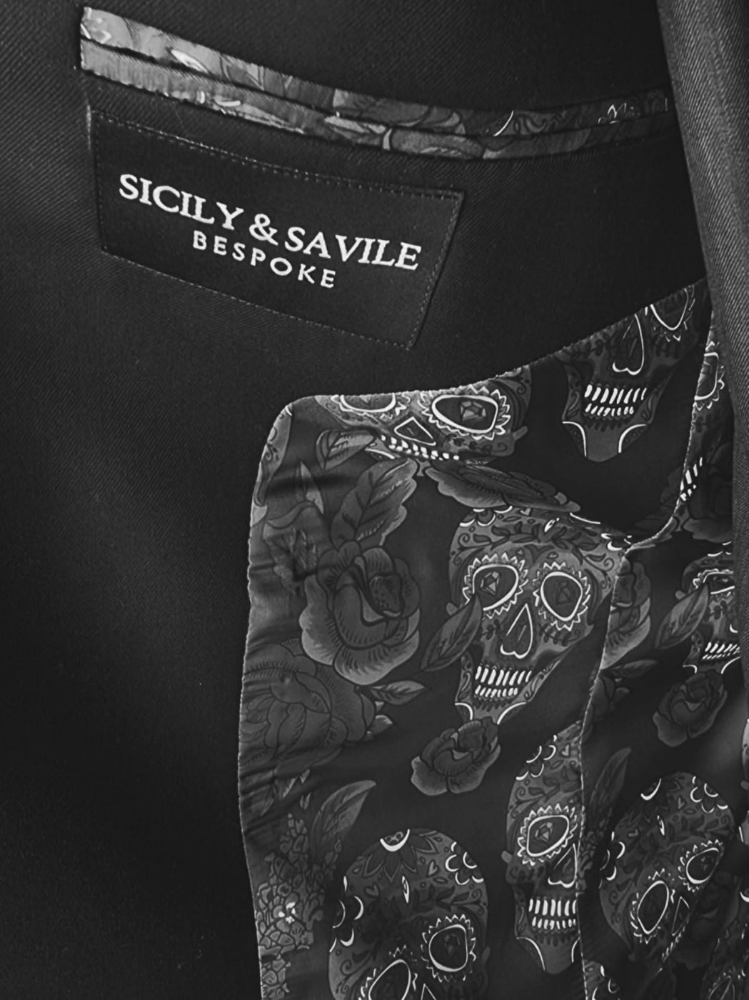 The Sicily & Savile Bespoke label inside a jacket, above a printed skull-and-rose lining