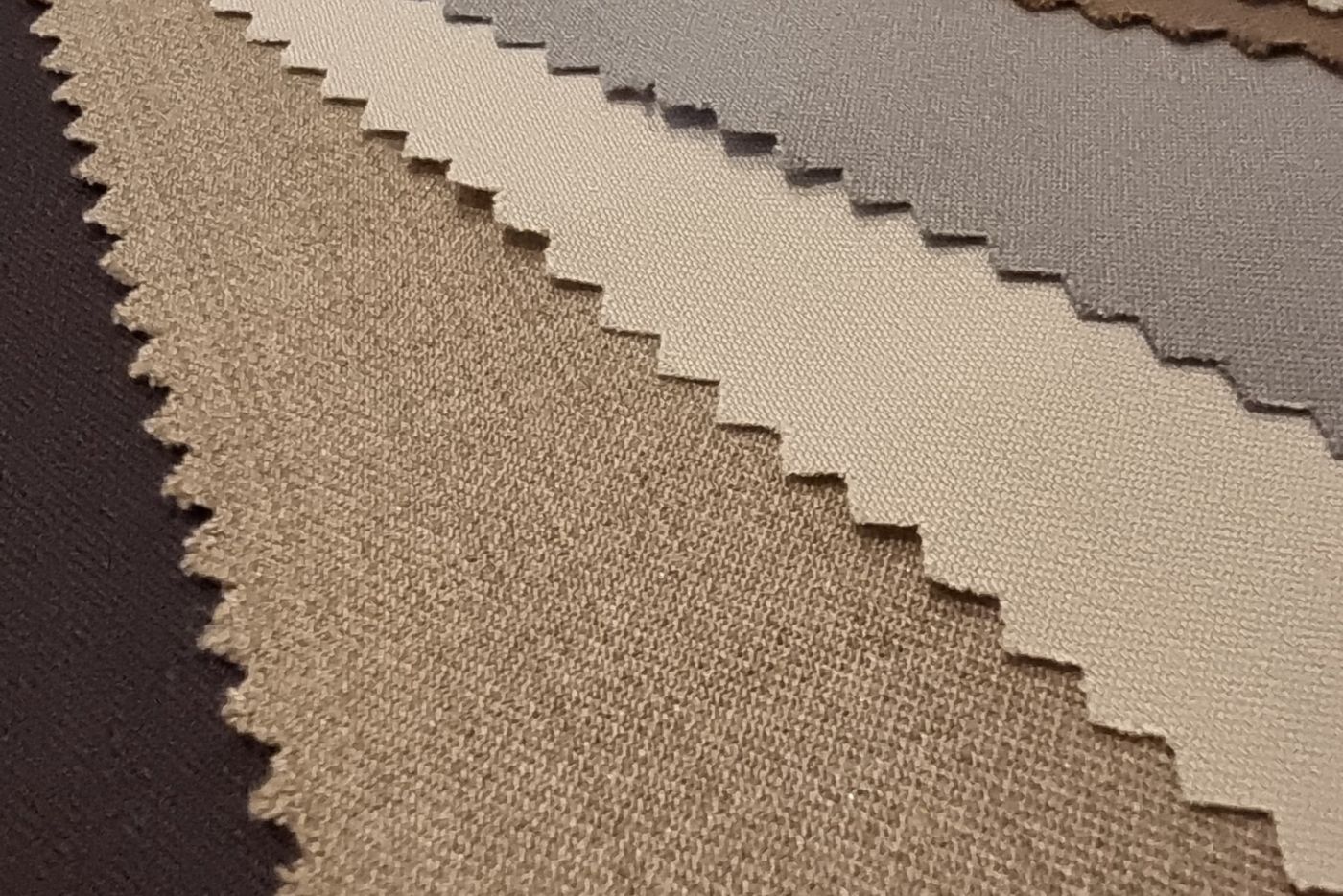 Pinked cloth swatches fanned out in taupe, stone and charcoal